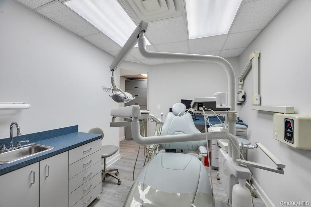 Medical treatment room featuring light gray walls and recessed fluorescent lighting