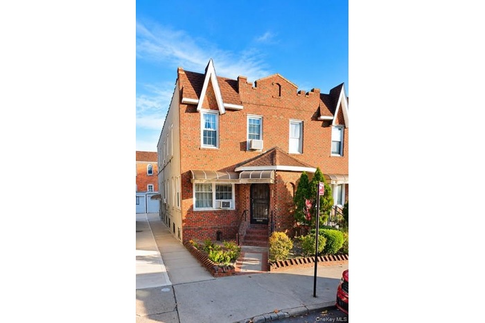 Brick facade residence with a gabled roofline and front garden beds