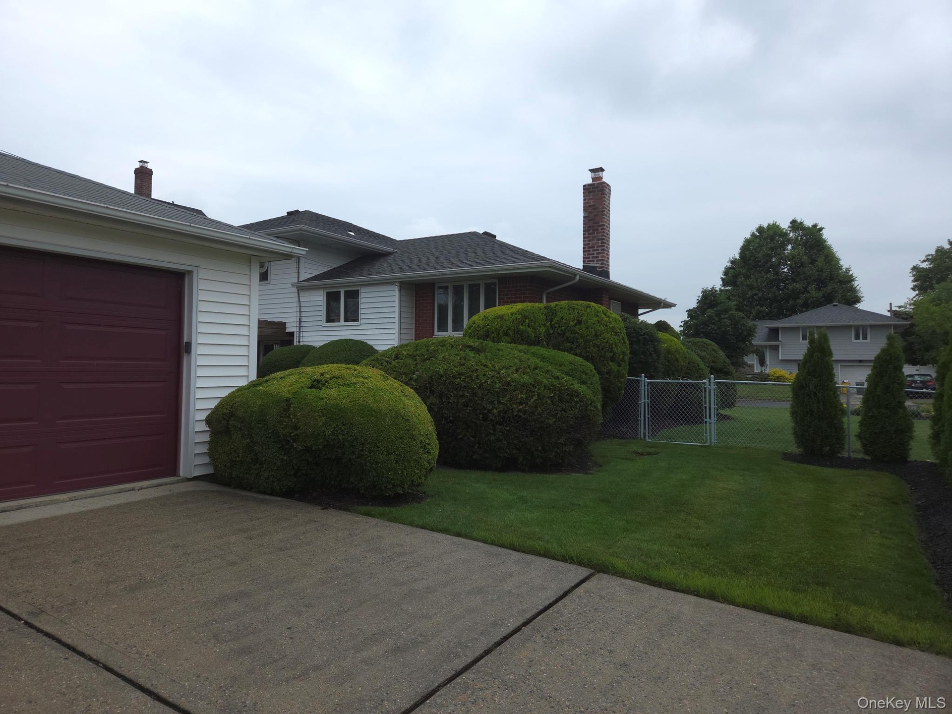 Detached 2 car garage featuring white horizontal siding, a dark red garage door, and a coordinating dark red side door