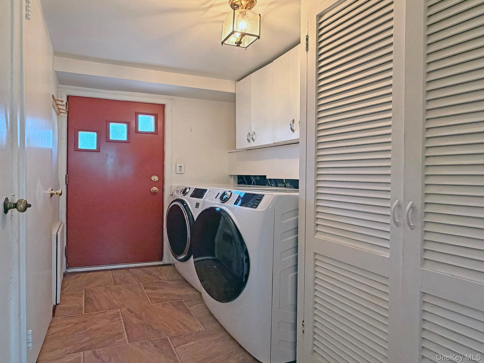 Dedicated laundry area featuring modern front-loading appliances