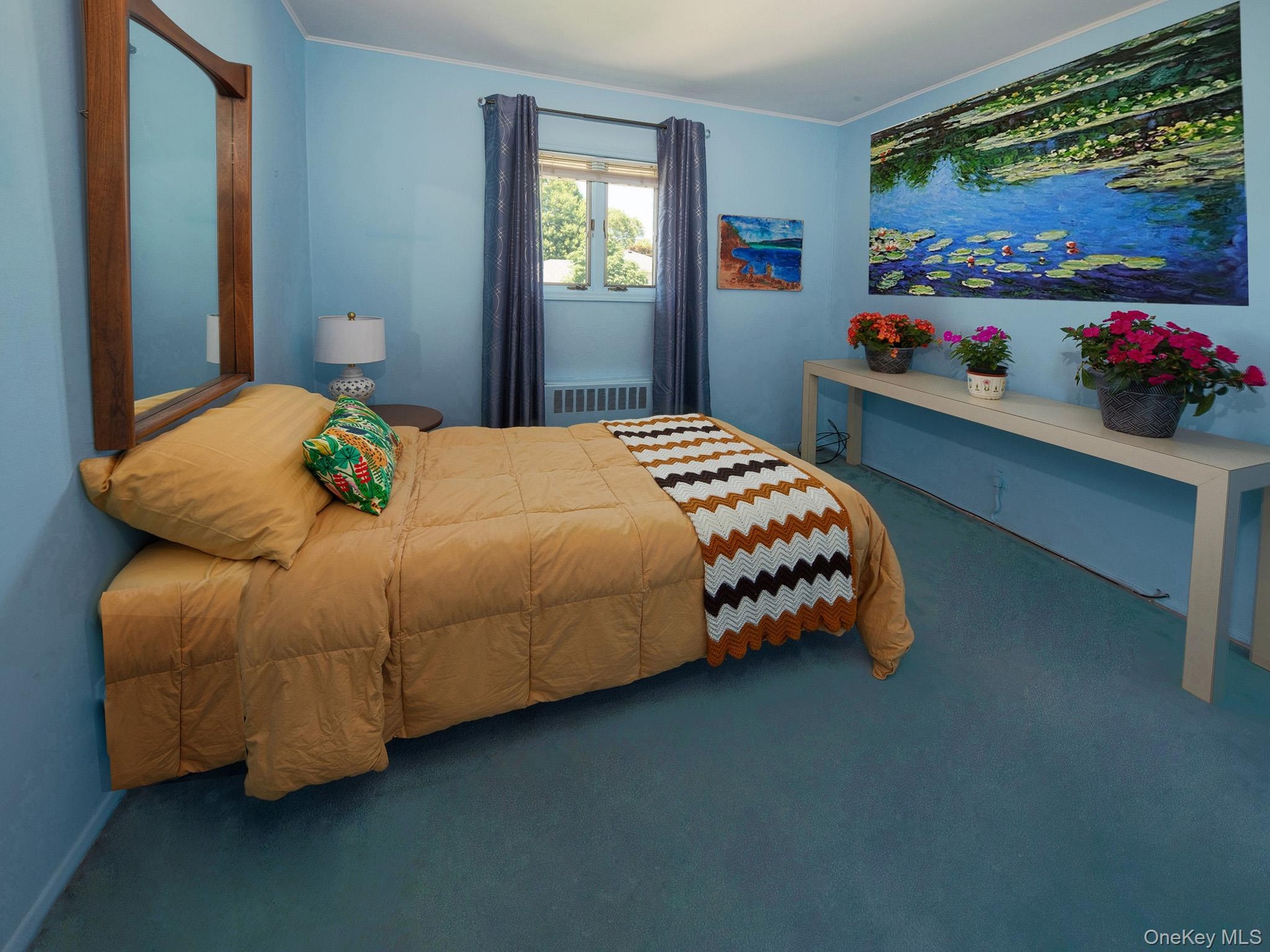 Carpeted interior space featuring a window with drapes, a wall-mounted mirror with a wood frame, and a built-in radiator