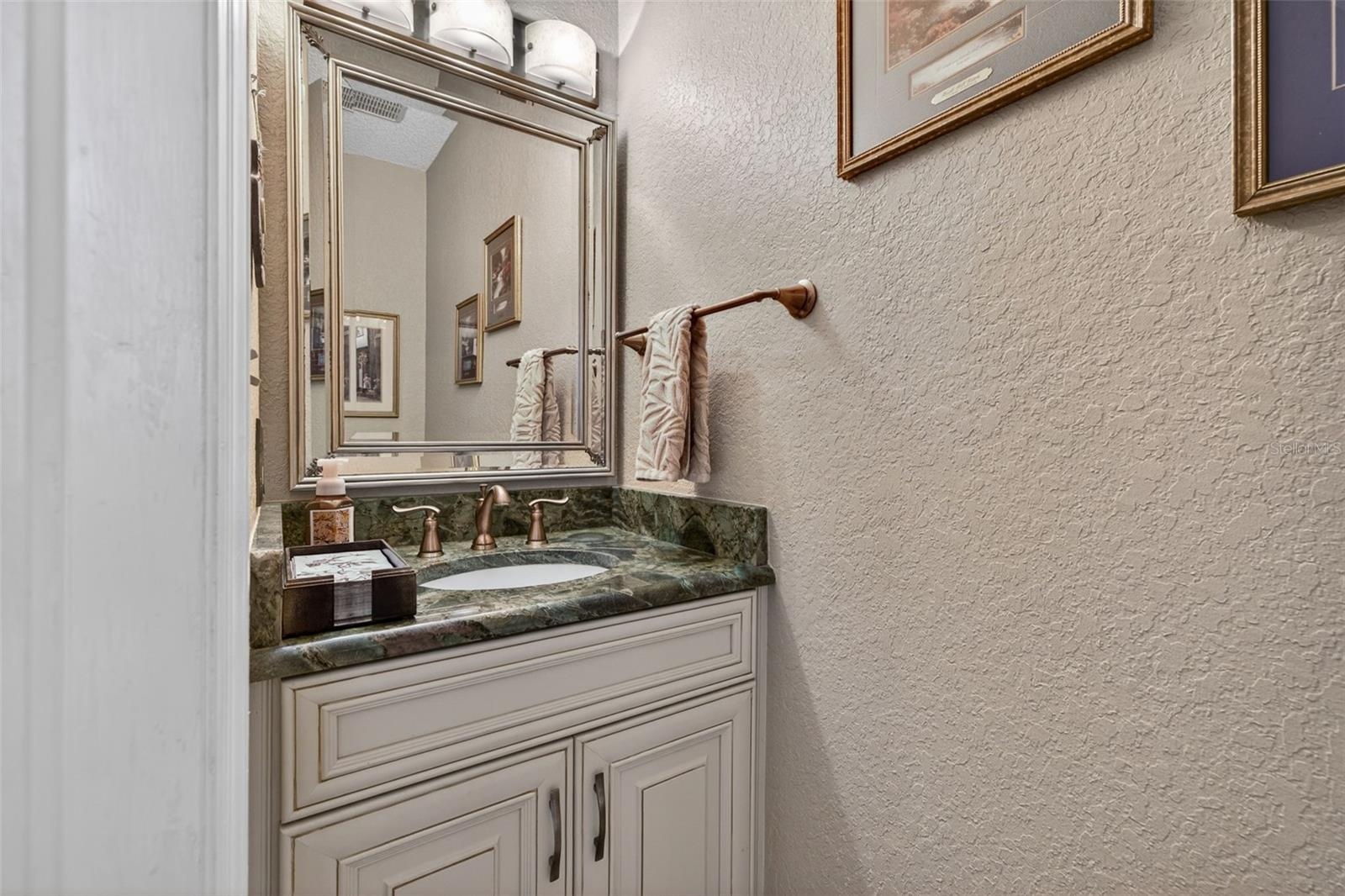 Lovely powder room conveniently located in the hallway to the laundry room
