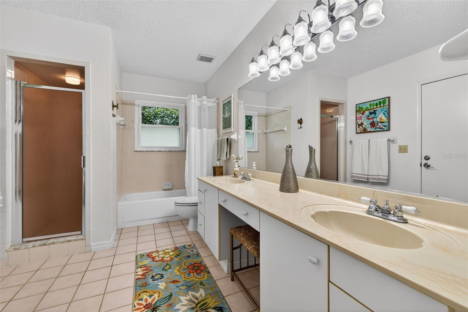Extra-large secondary bath not only offers 2 sinks, but 2 showers as well. An exterior door leads to the covered back porch to serve as a future pool 