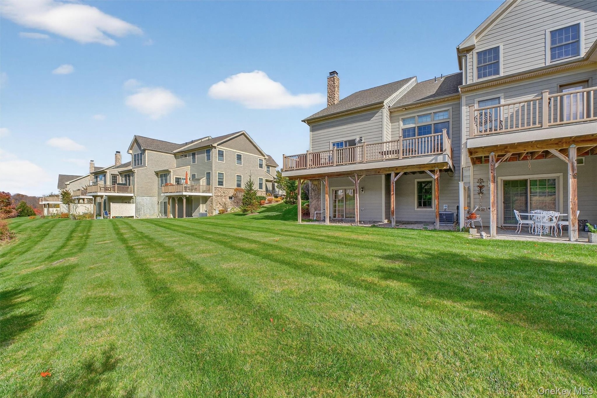 Rear view of property with a yard, a chimney, a patio area, a residential view, and a wooden deck