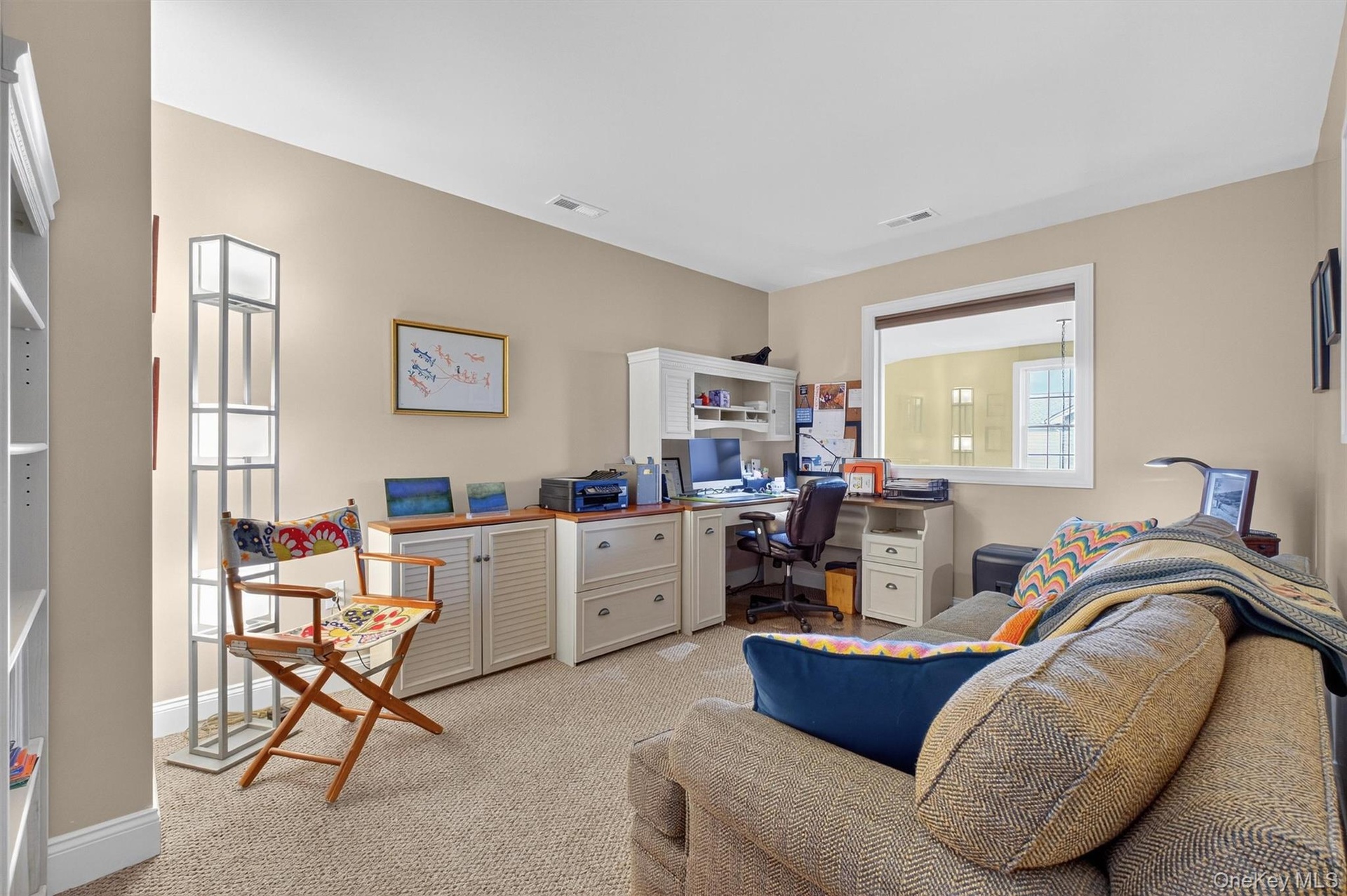 Home office with light colored carpet and baseboards
