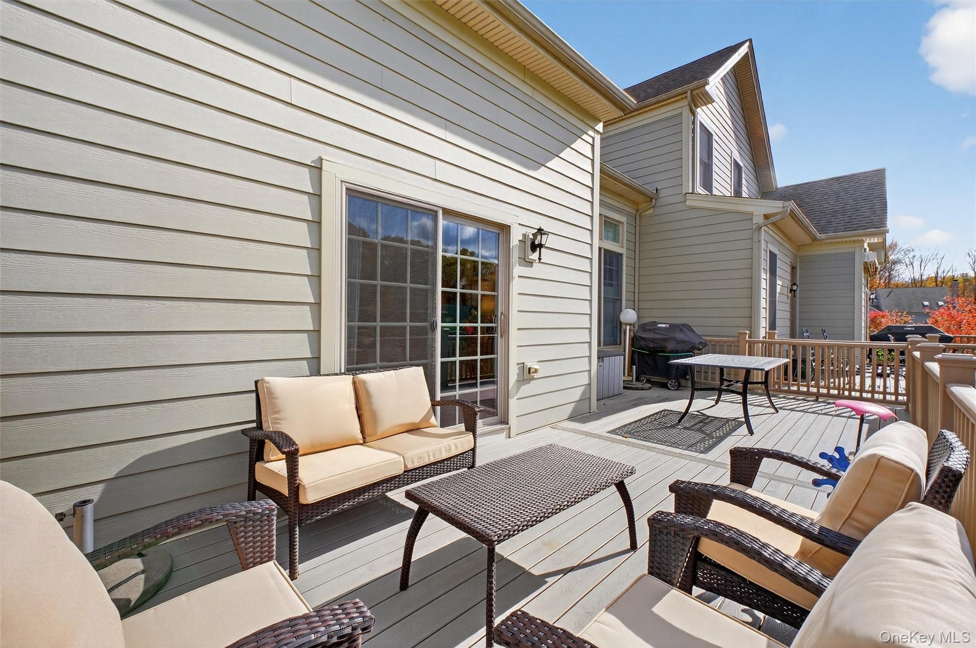 Wooden terrace with an outdoor hangout area and grilling area