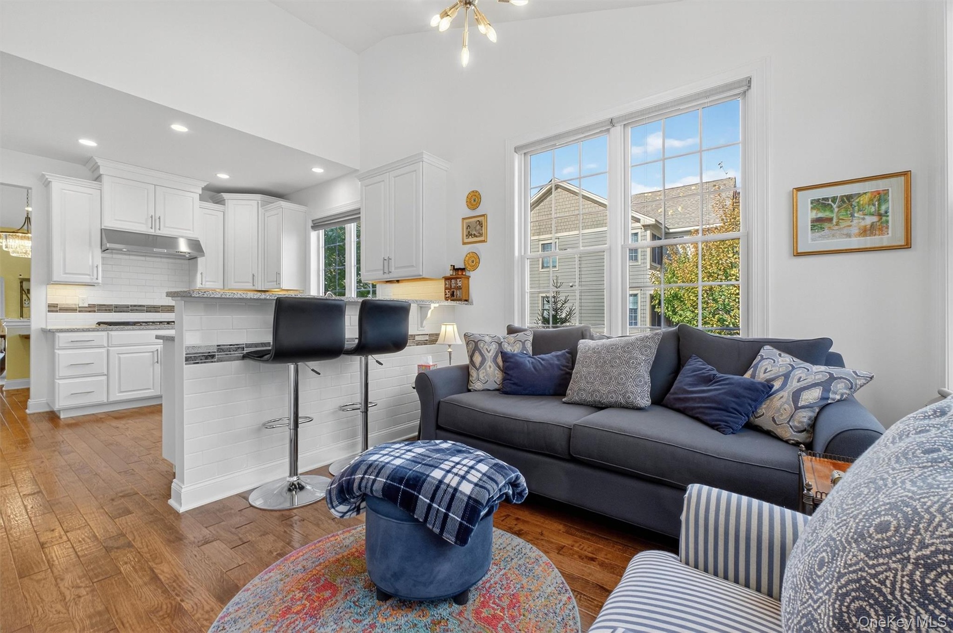 Living area with a chandelier, dark wood-style floors, recessed lighting, and lofted ceiling