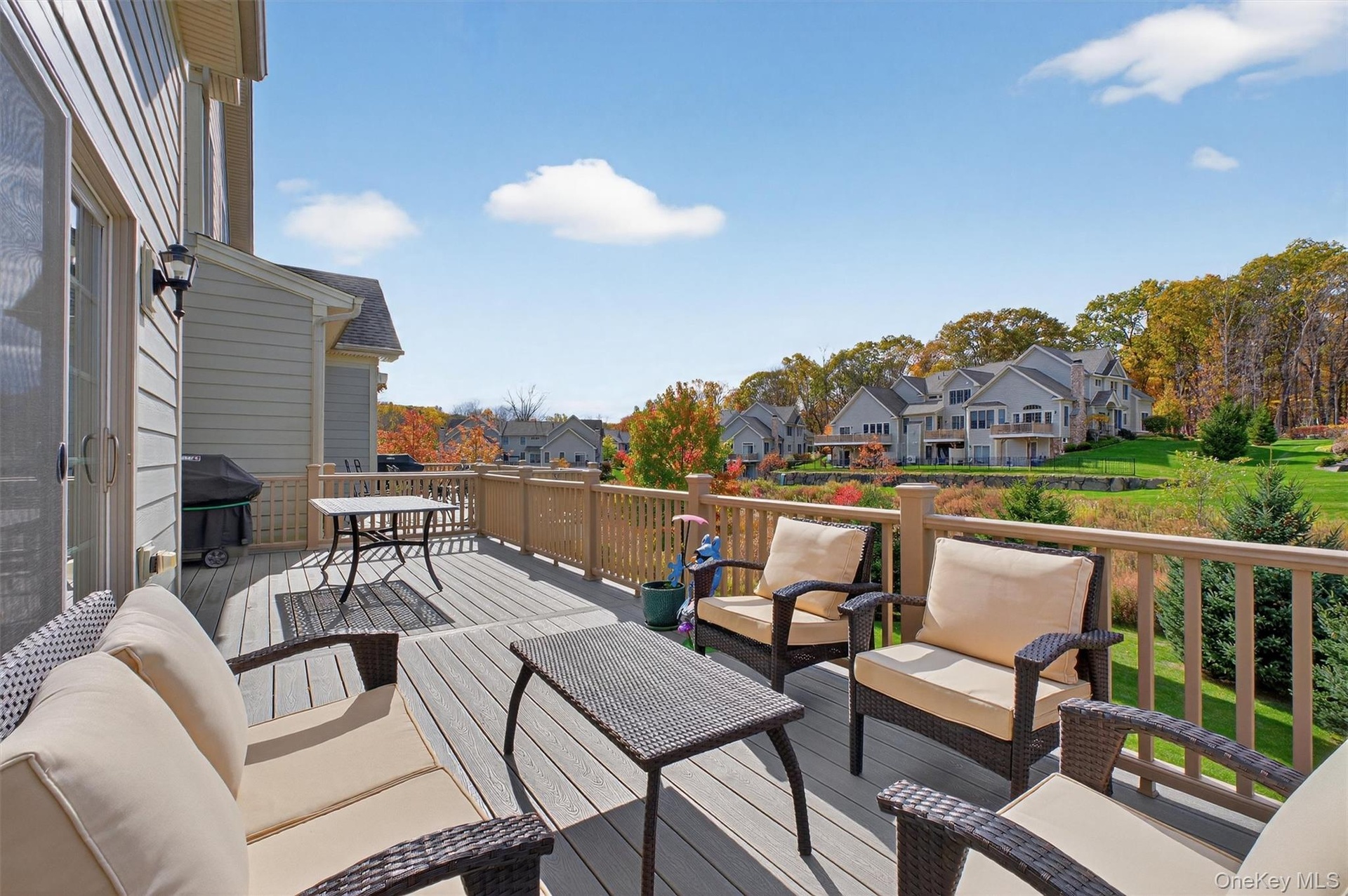 Wooden terrace with an outdoor hangout area, a residential view, and grilling area