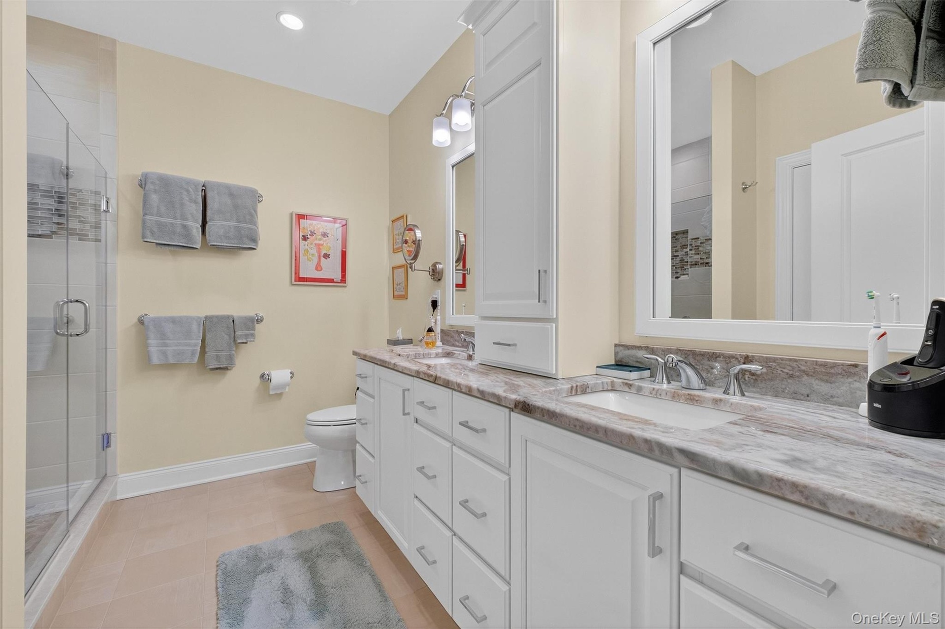 Bathroom featuring double vanity, a shower stall, recessed lighting, and light tile patterned flooring