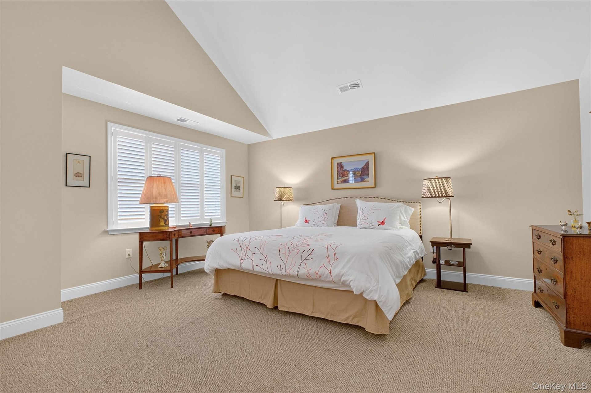 Bedroom with high vaulted ceiling and light colored carpet