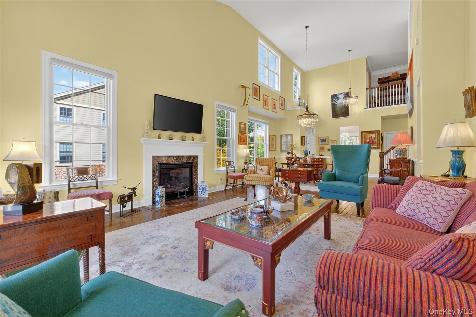 Living area featuring wood finished floors, a premium fireplace, and a high ceiling