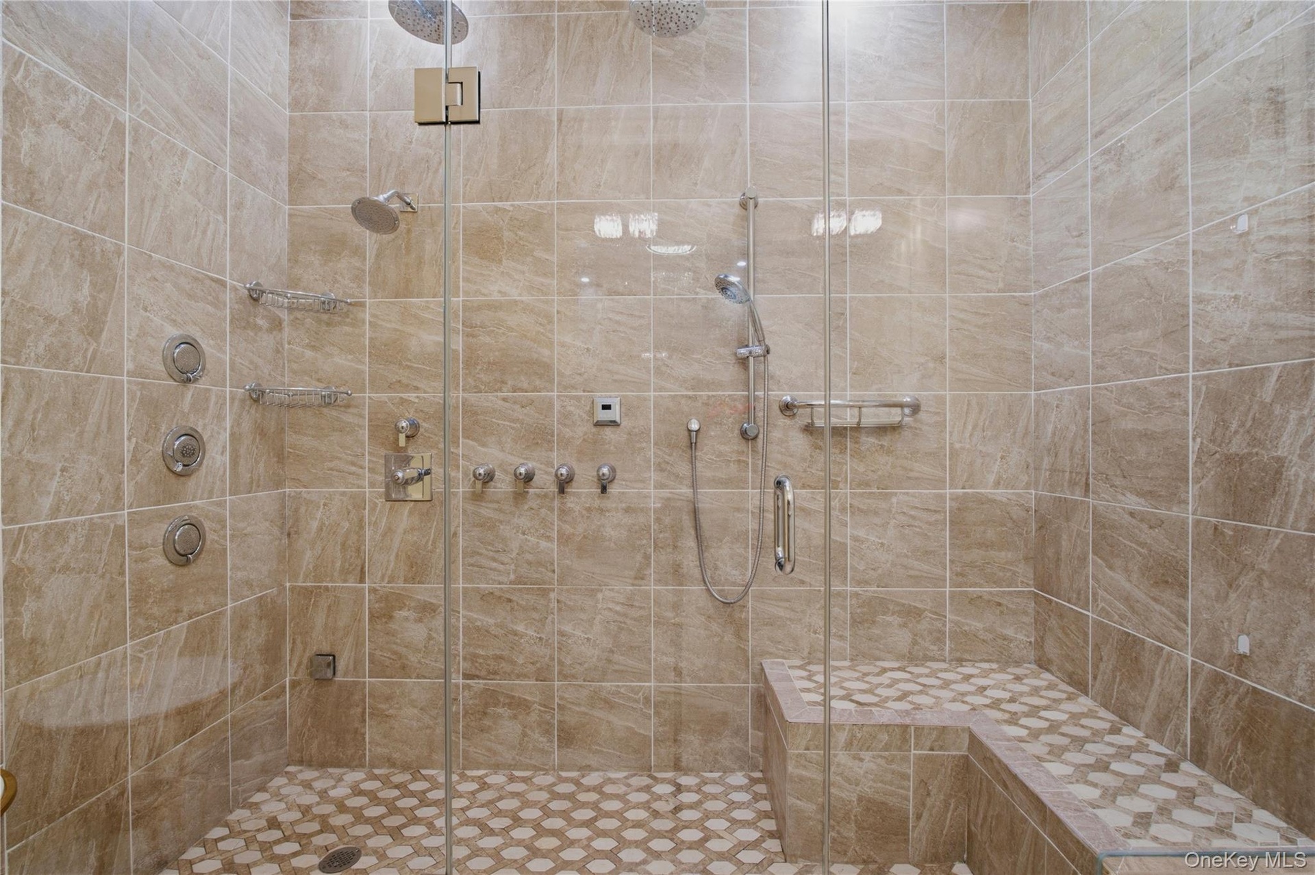 Close-up of the oversized spa-inspired shower showcasing elegant tile work and sleek modern finishes.