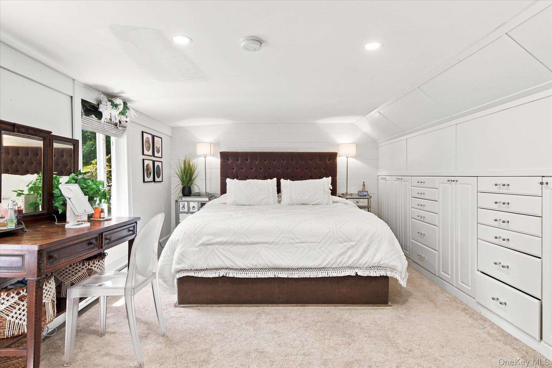 Primary bedroom with built in dressers and brand new oversized pella windows