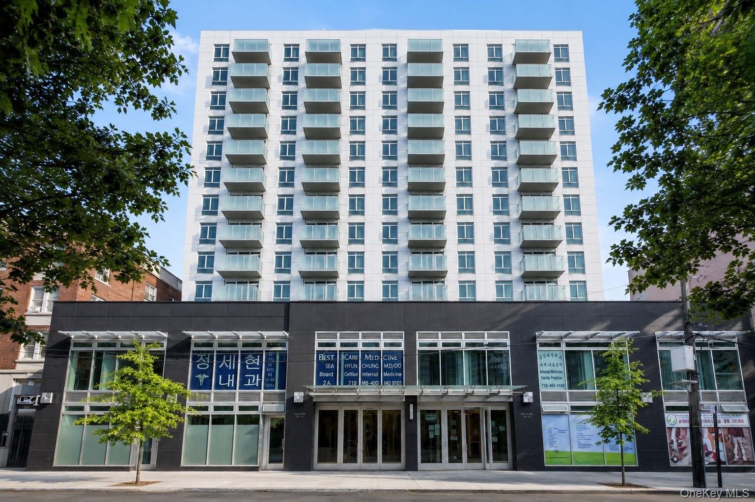 Modern high-rise building featuring a white facade and numerous private balconies with glass railings