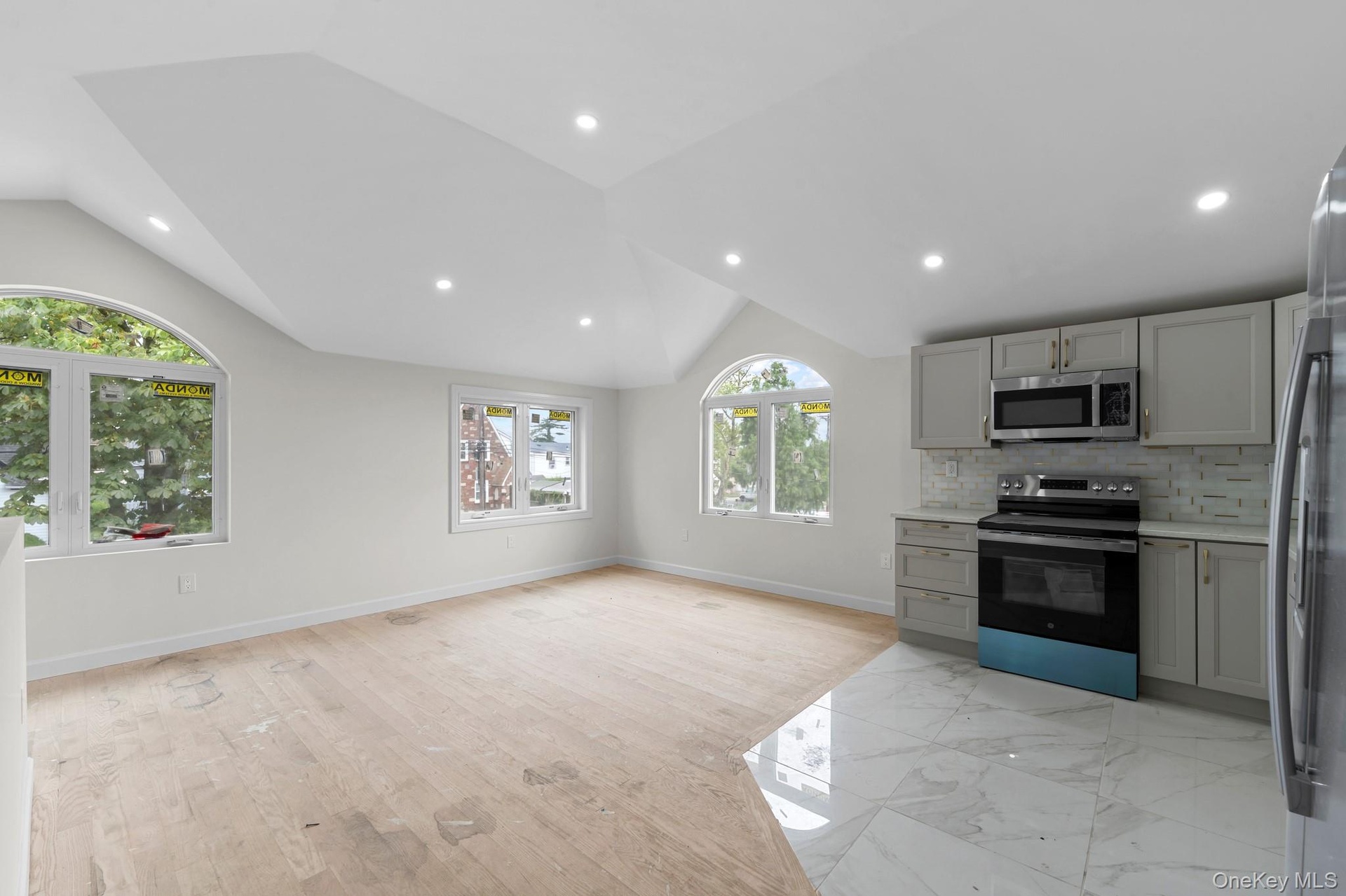 Open-concept living space with vaulted ceilings and recessed lighting