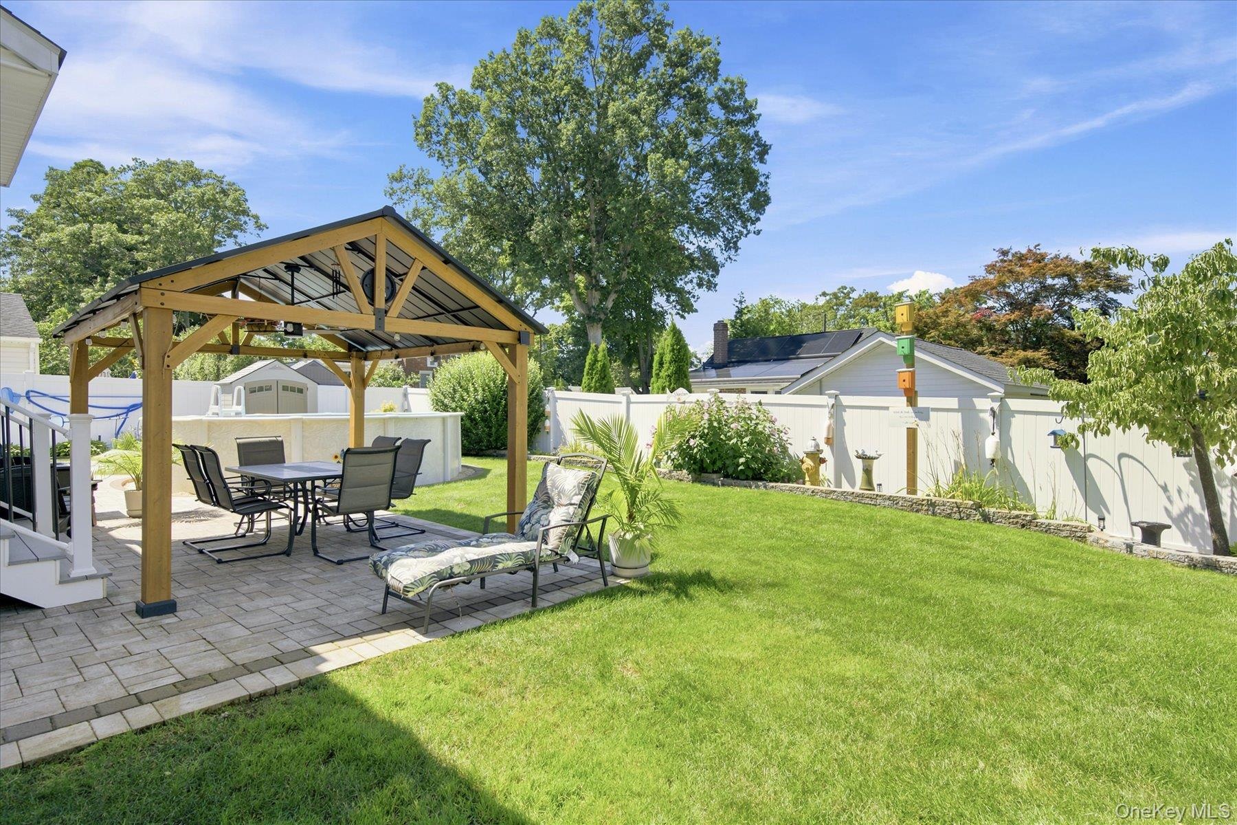 Gorgeous back yard with paver Patio with pergola, new vinyl fencing, back yard fountain and heated above ground pool