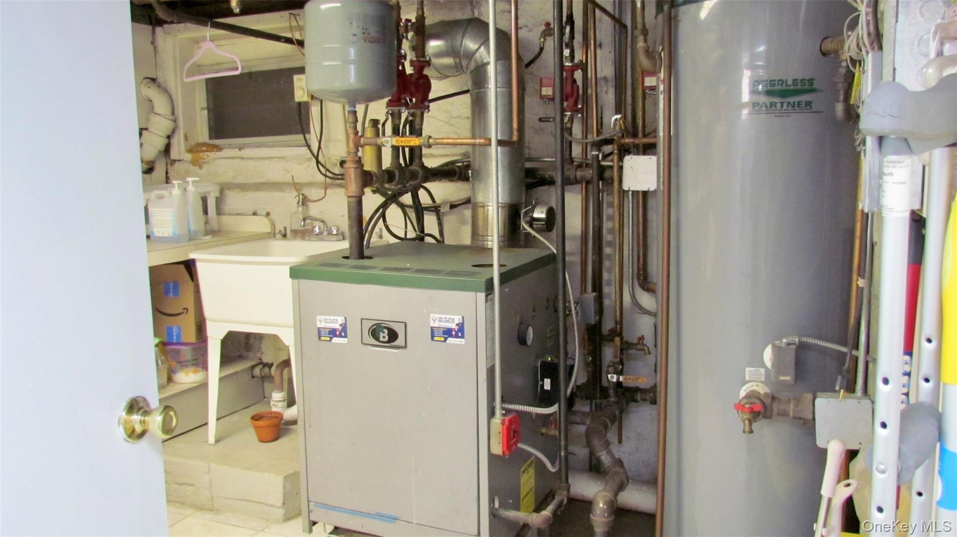 Utility area featuring a boiler, water heater, and a utility sink
