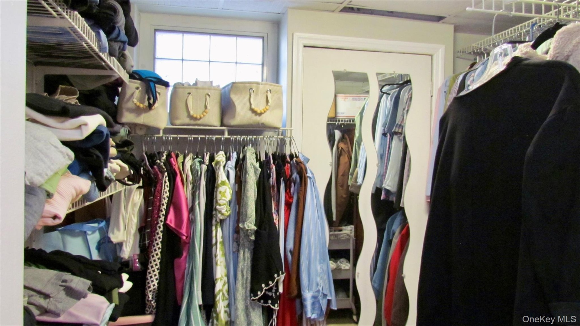 Custom walk-in closet system featuring wire shelving and hanging rods