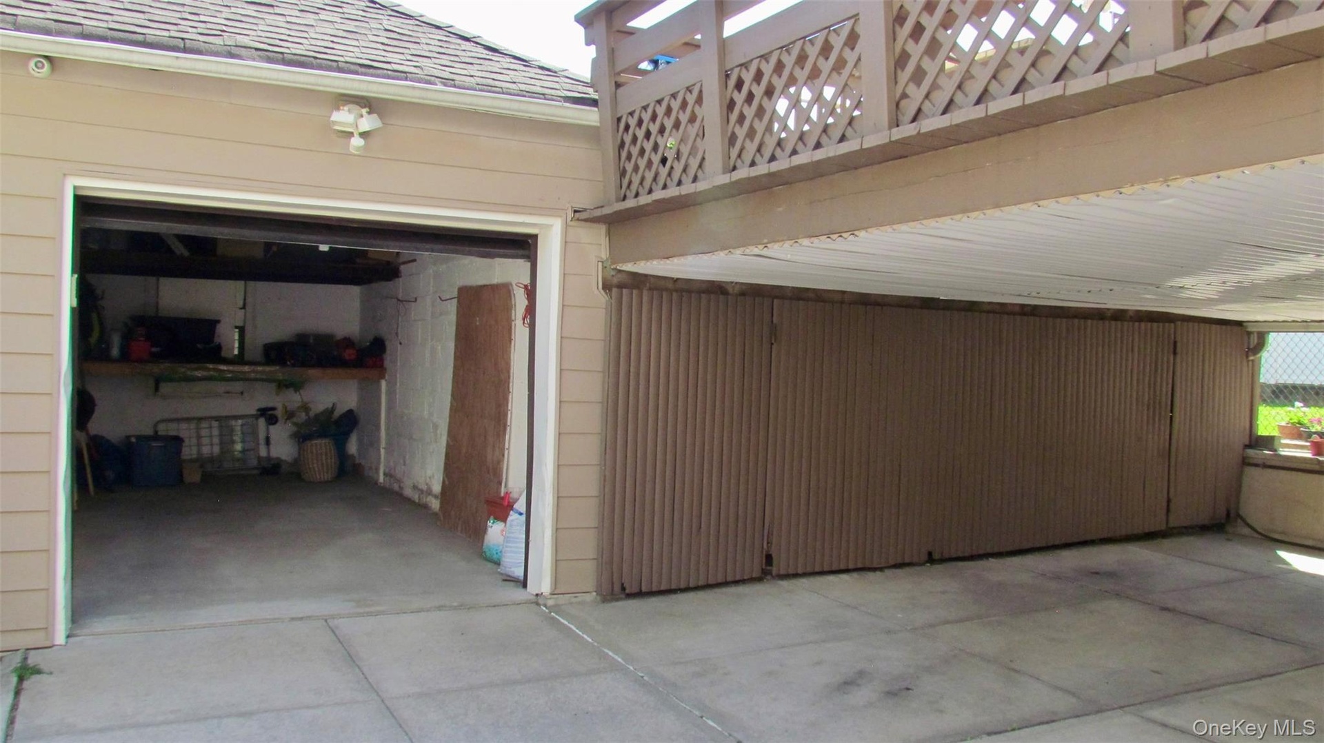 One-car garage and additional covered parking pad with a lattice-style railing overhead
