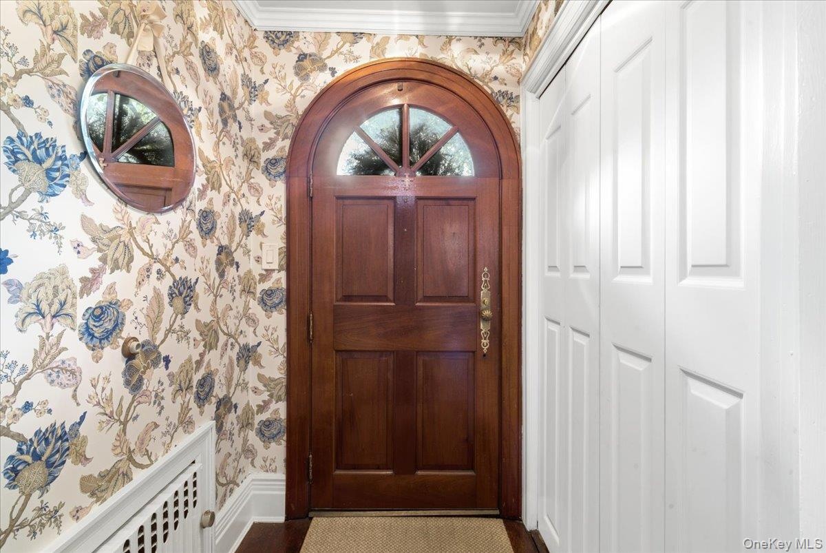 Charming Vestibule with wallpaper and coat closet