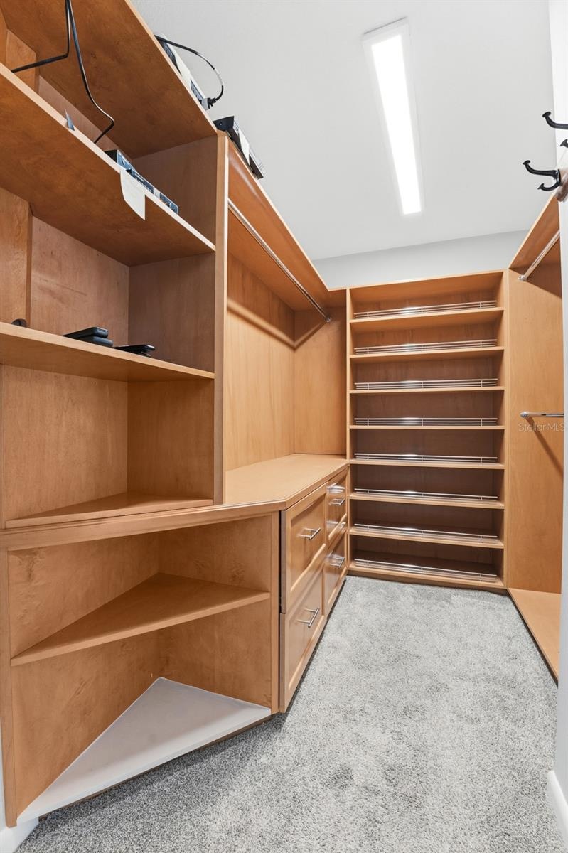 primary bedroom walk in closet with built ins.