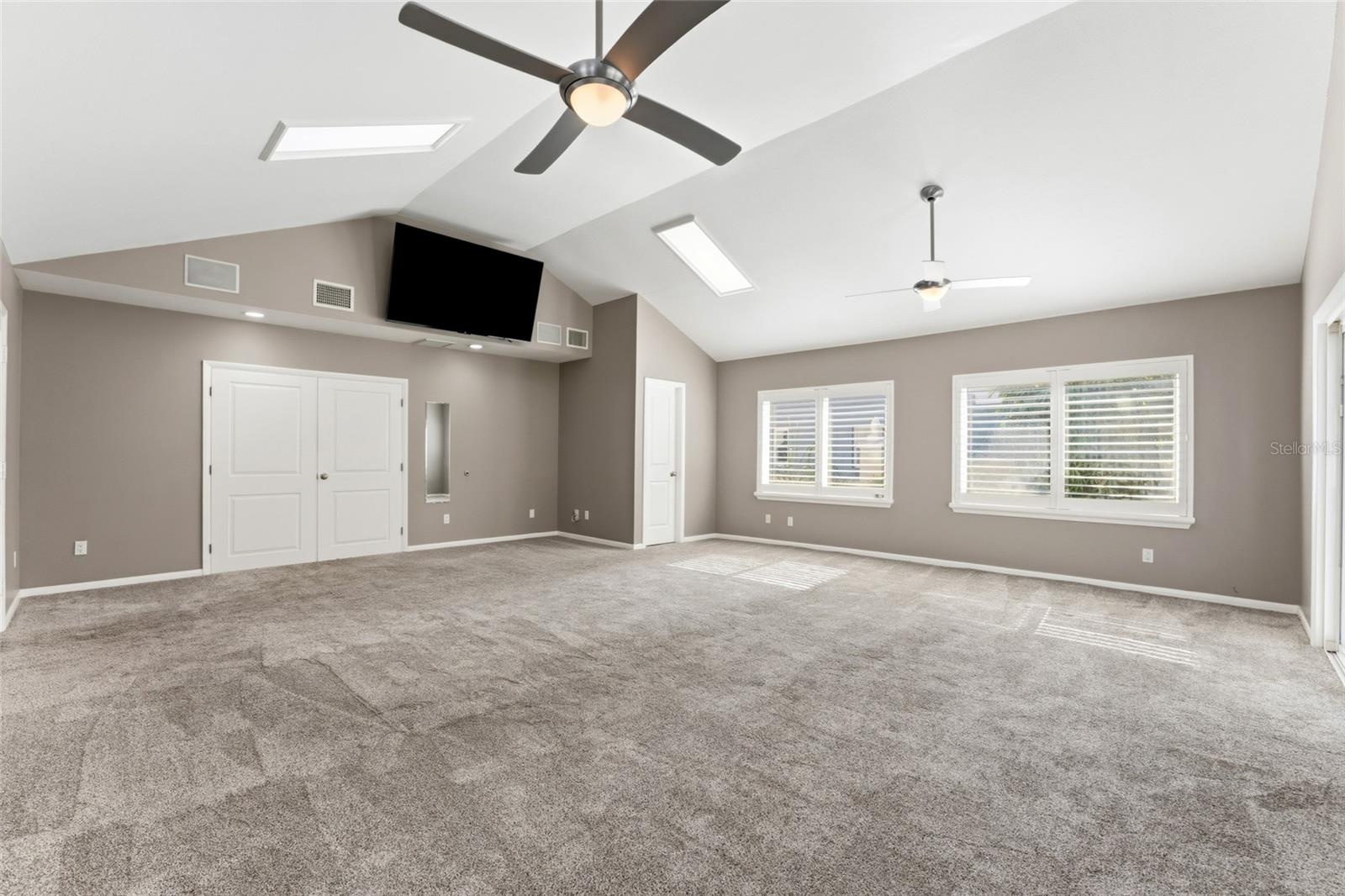 large bonus room with french doors into primary bedroom
