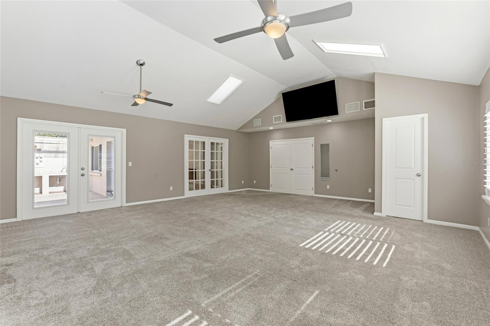 large bonus room with french doors into dining/formal living room and primary bedroom