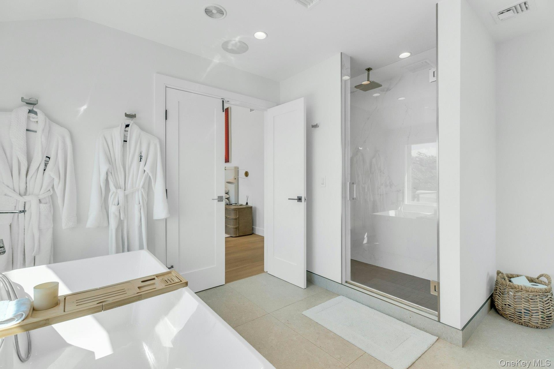 Contemporary bathroom featuring a freestanding soaking tub and a spacious glass-enclosed shower with a rainfall showerhead