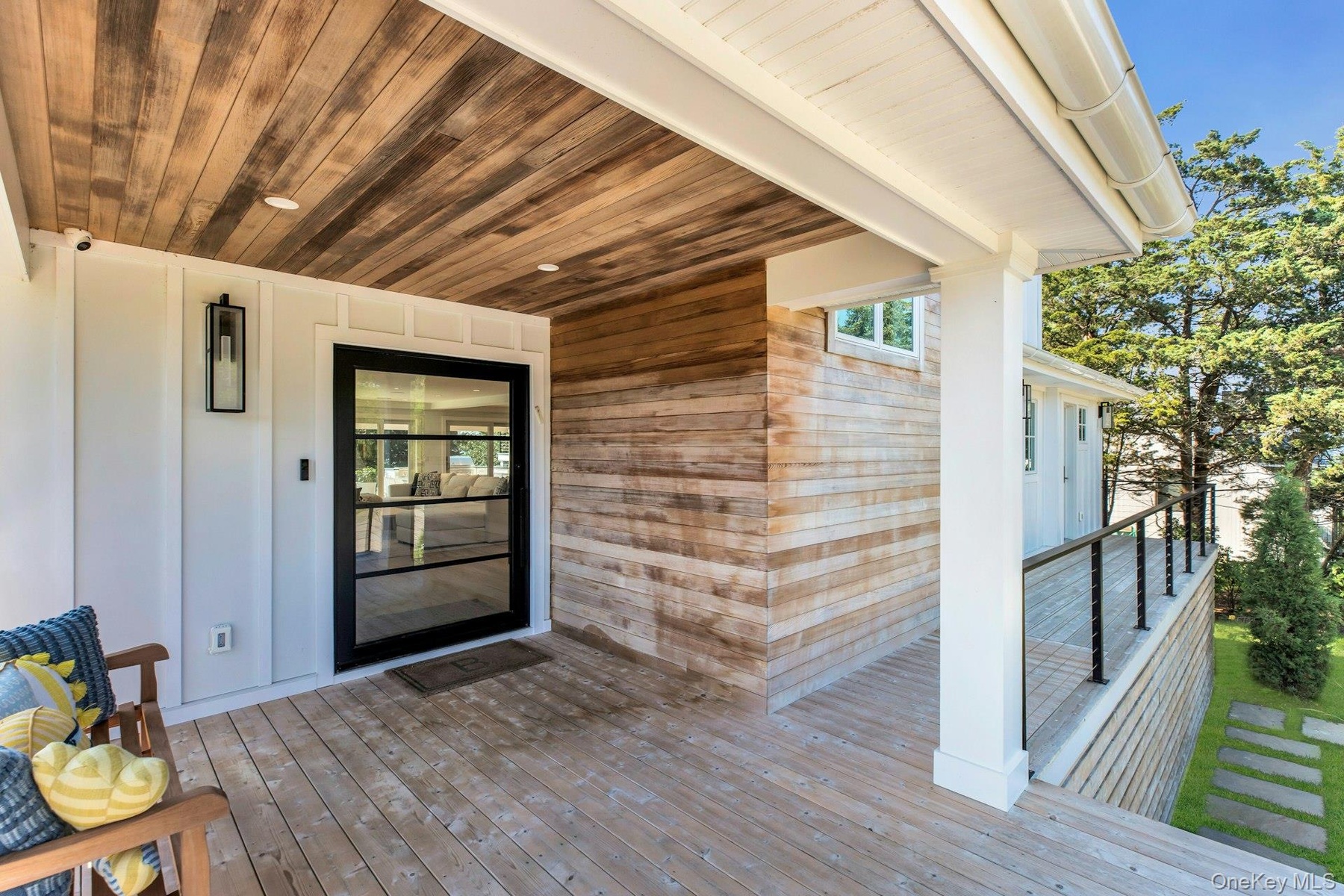 Covered porch featuring a wood-plank ceiling, wood-finish flooring, and white paneled walls