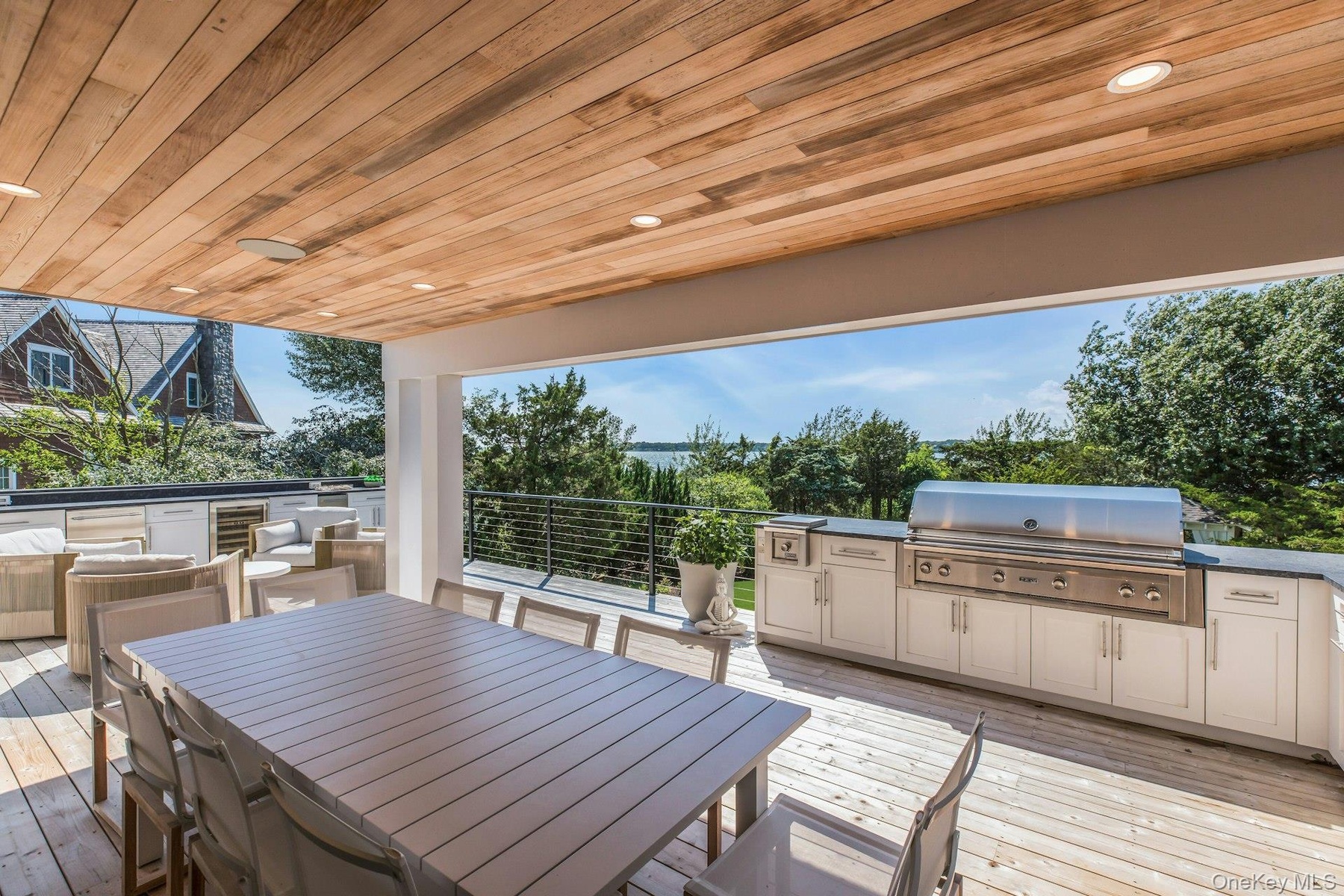 Expansive covered outdoor deck featuring a wood-finish ceiling, recessed lighting, and wood-finish flooring
