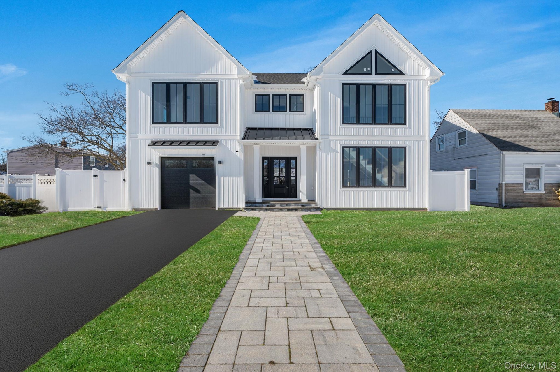 Modern Colonial exterior with board and batten style siding, black framed windows, and a covered entry that creates a strong, custom curb appeal.