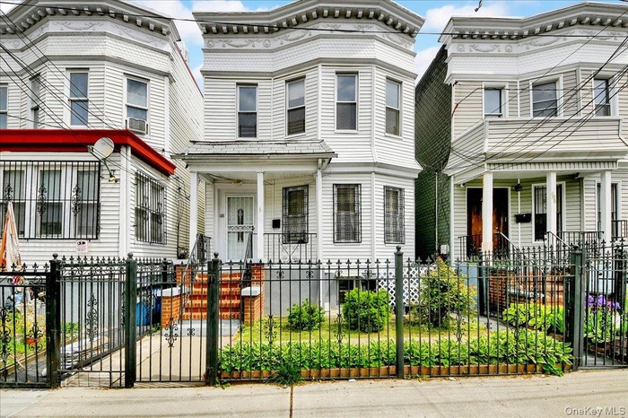 Two-story residence featuring white siding and bay windows on the upper level