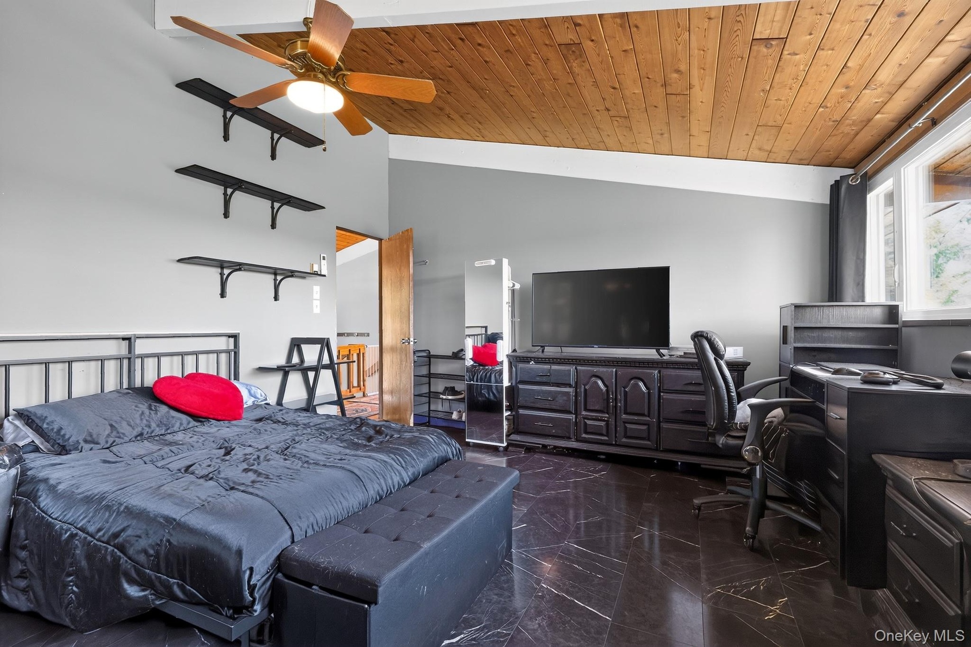 Vaulted wood-plank ceiling with a ceiling fan