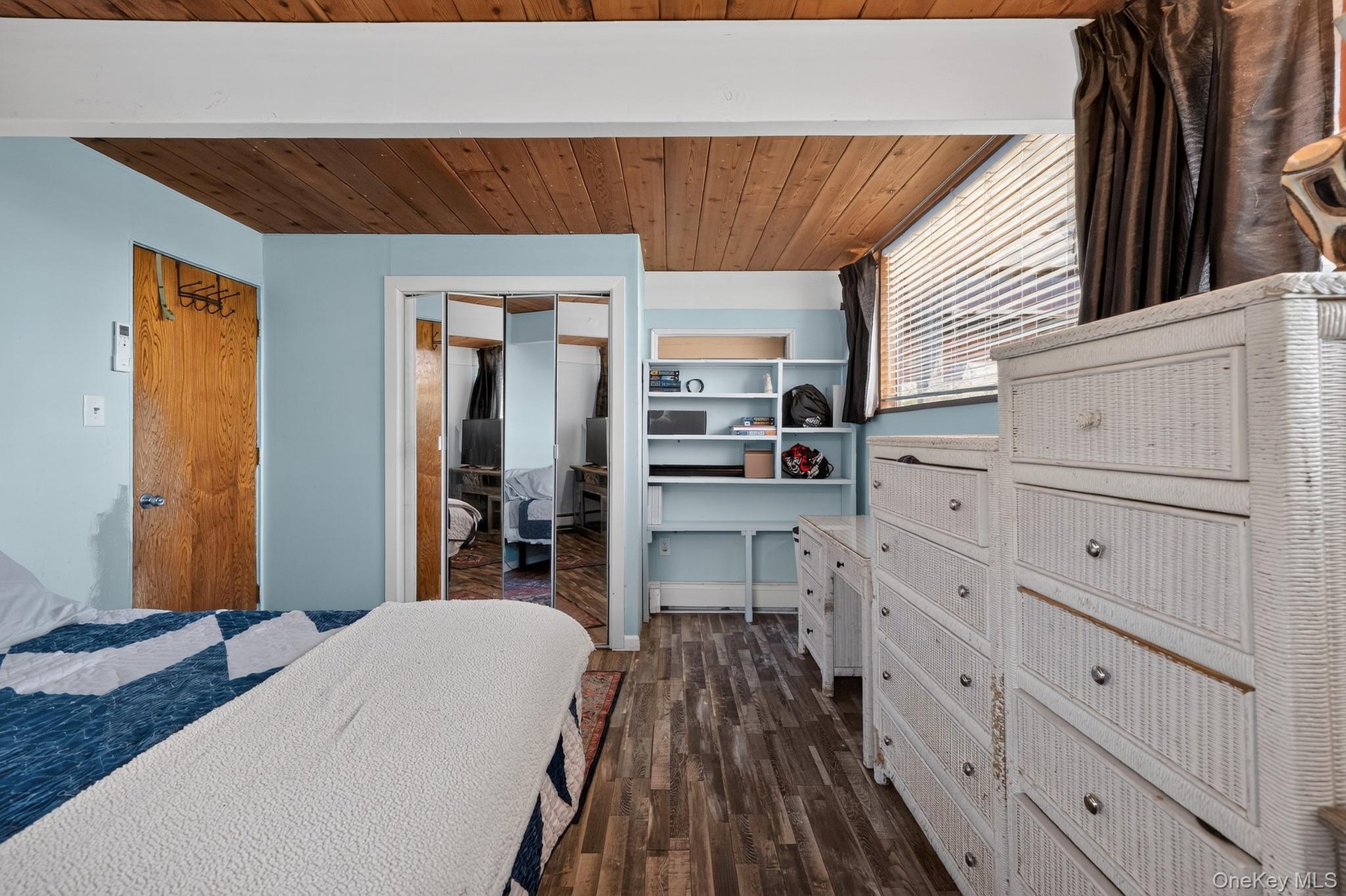 Wood-finish flooring throughout, complemented by a wood-paneled ceiling with exposed beams