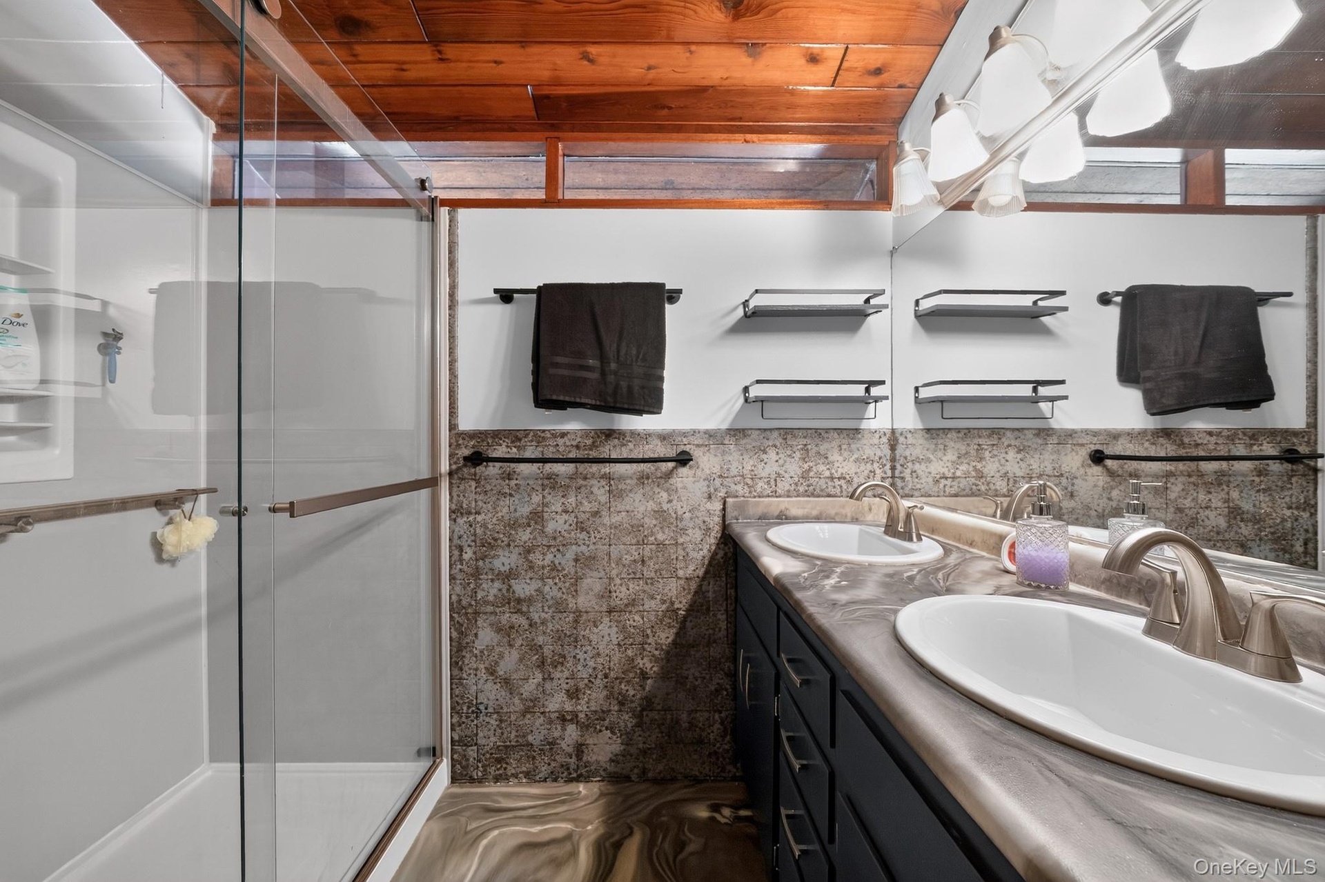 Dual vanity with integrated sinks, brushed nickel fixtures, and a large wall-mounted mirror