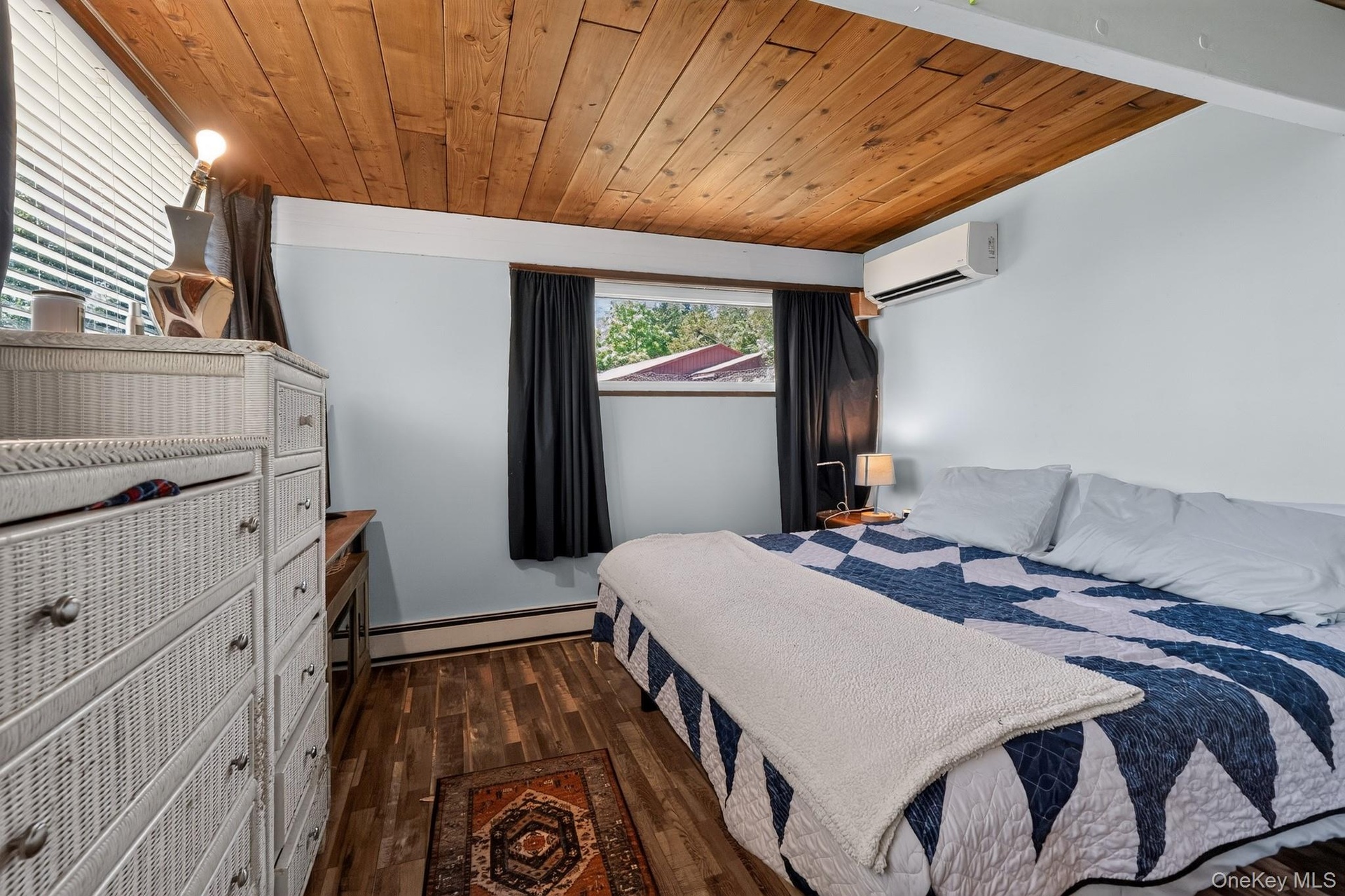 Room featuring wood-finish flooring, a natural wood paneled ceiling, and light blue walls