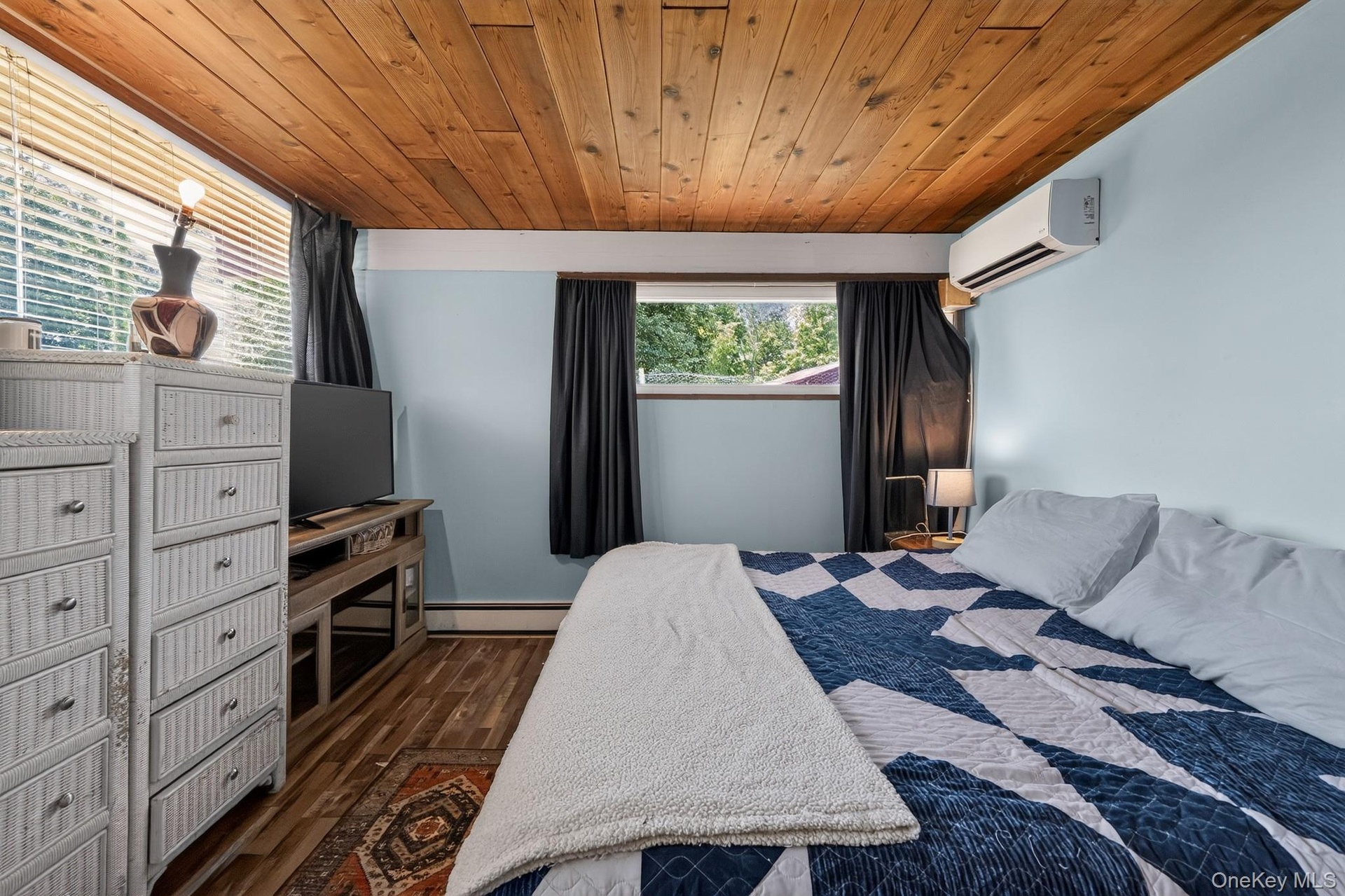 Room featuring a wood-finish ceiling, light blue walls, and wood-finish flooring