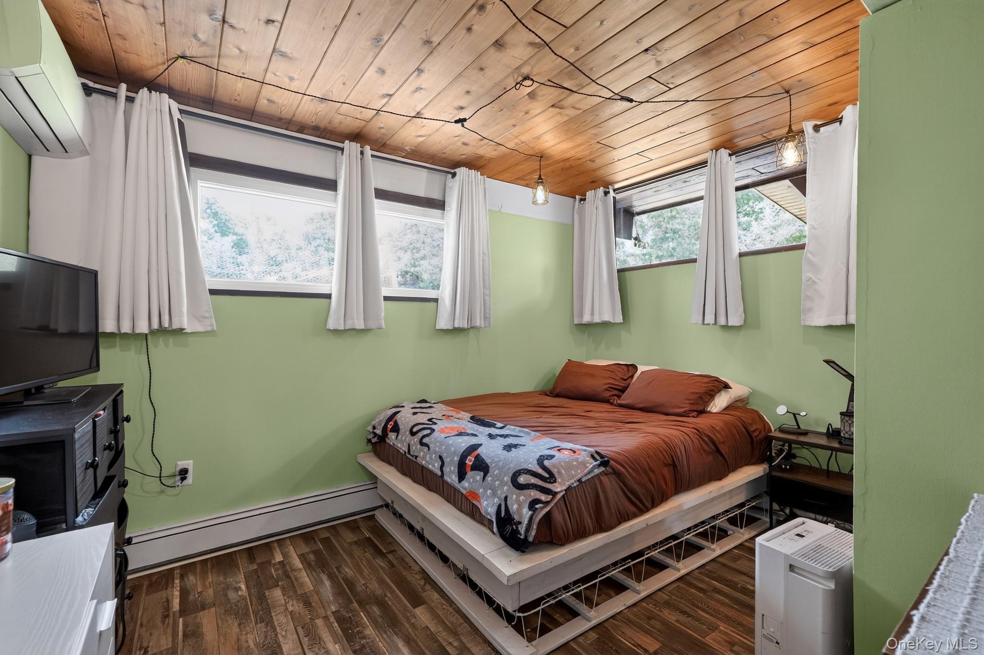 Room featuring wood-finish flooring, a wood plank ceiling, and light green painted walls