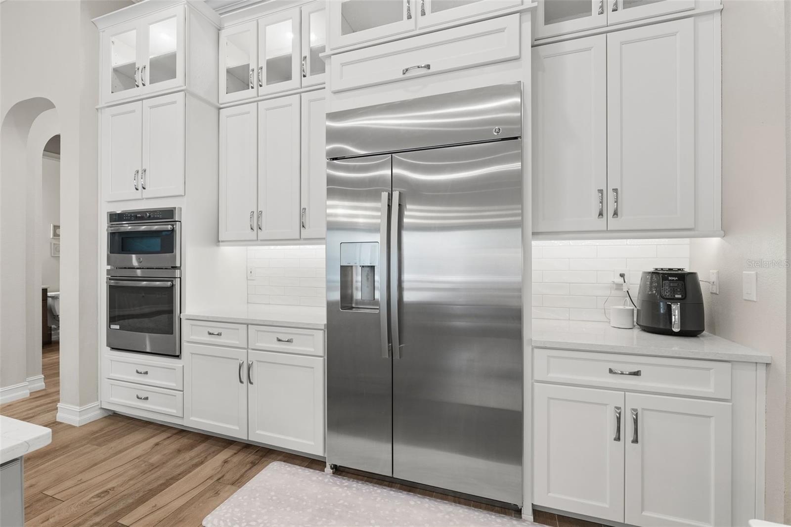 Built-in oversized refrigerator accompanies the stunning floor to ceailing cabinetry.