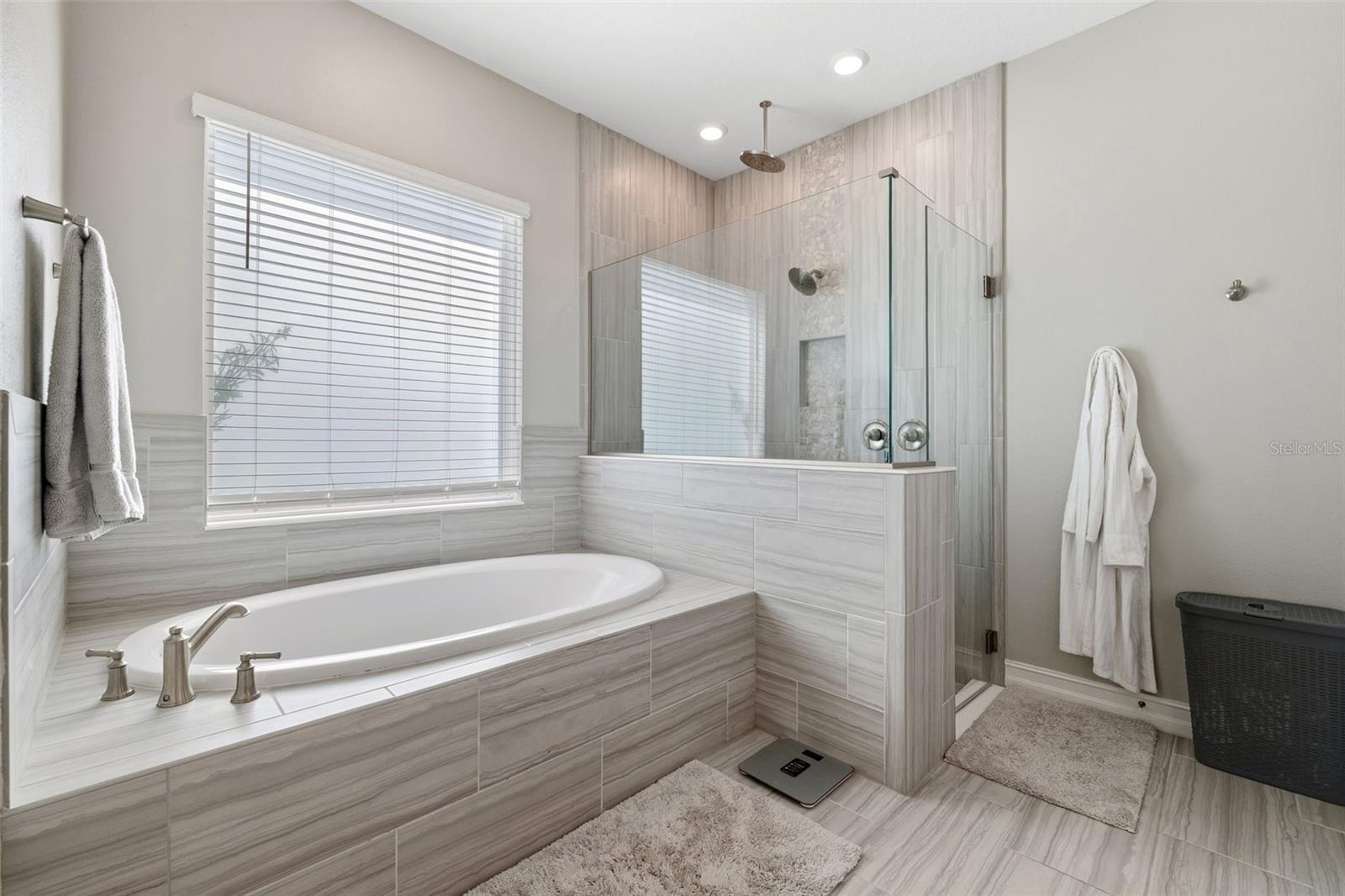 The primary bathroom offers an oversized walk-in shower and a separate soaking tub to relax in.