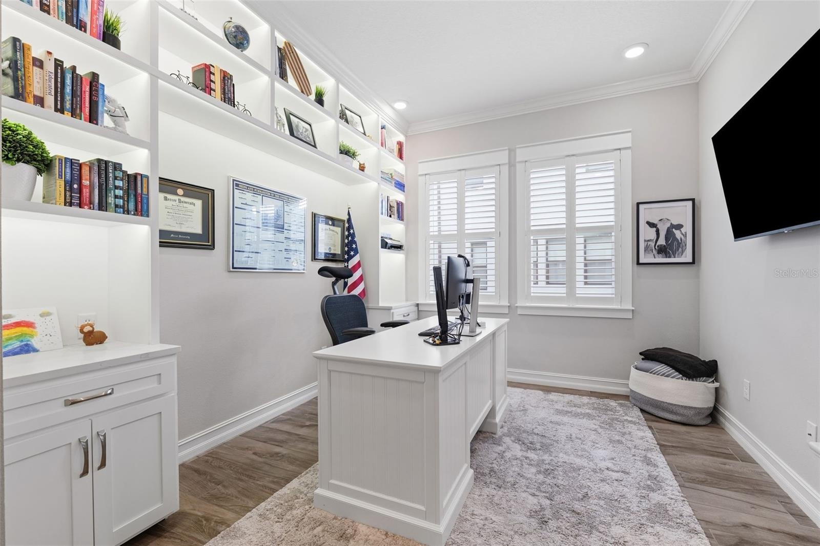 Custom shelving with built-in lighting brings this home office to life.