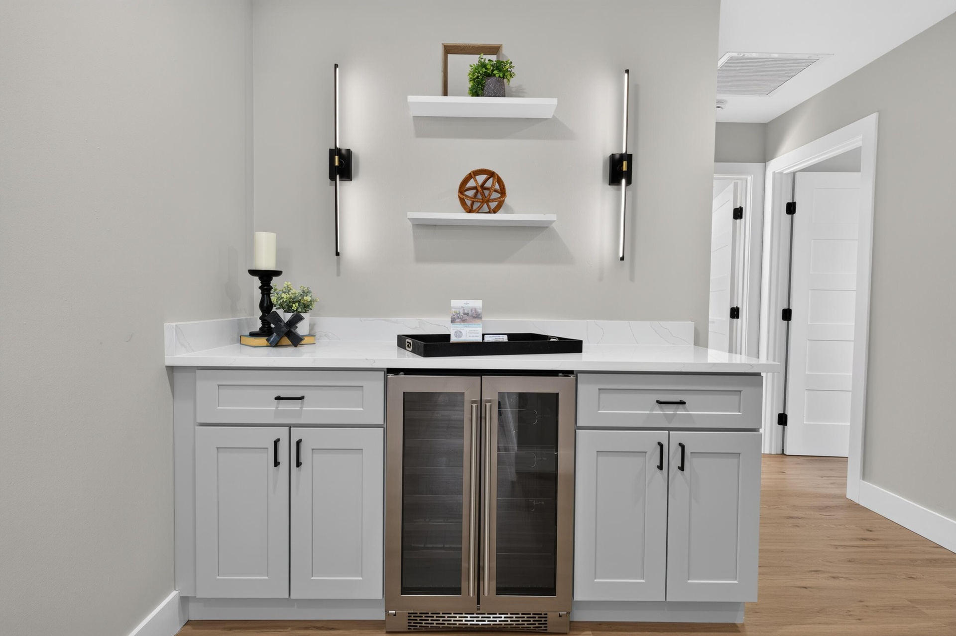 Custom dry bar featuring a white countertop, light gray cabinetry, and an integrated beverage cooler