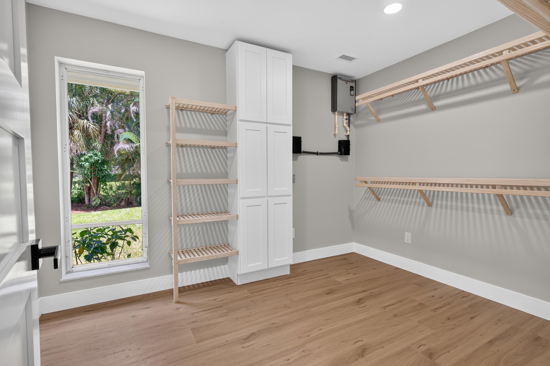 Room featuring wood-finish flooring, white baseboards, and light gray walls
