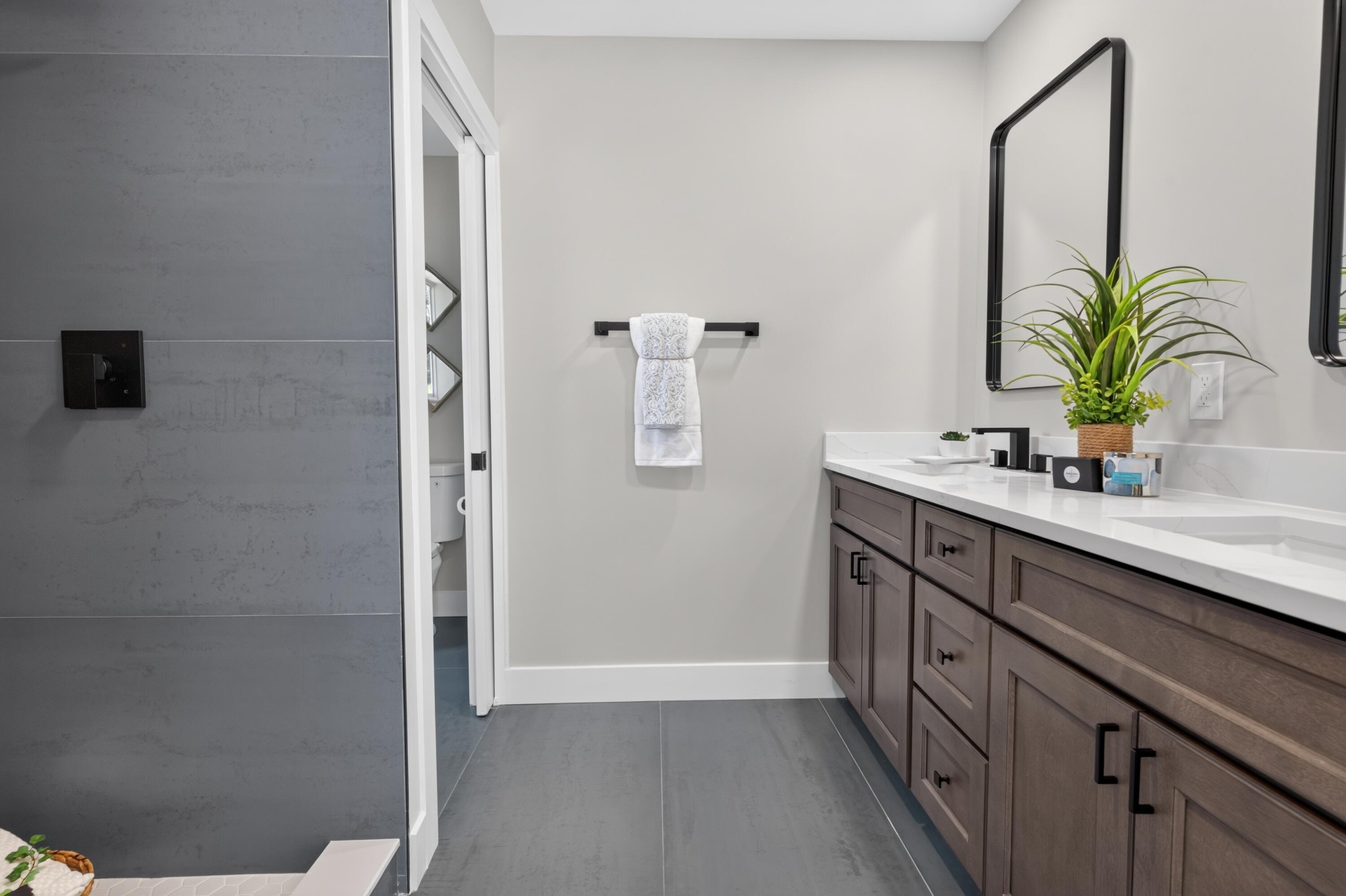 Bathroom featuring a double vanity with dark wood cabinetry, white countertops, and integrated sinks