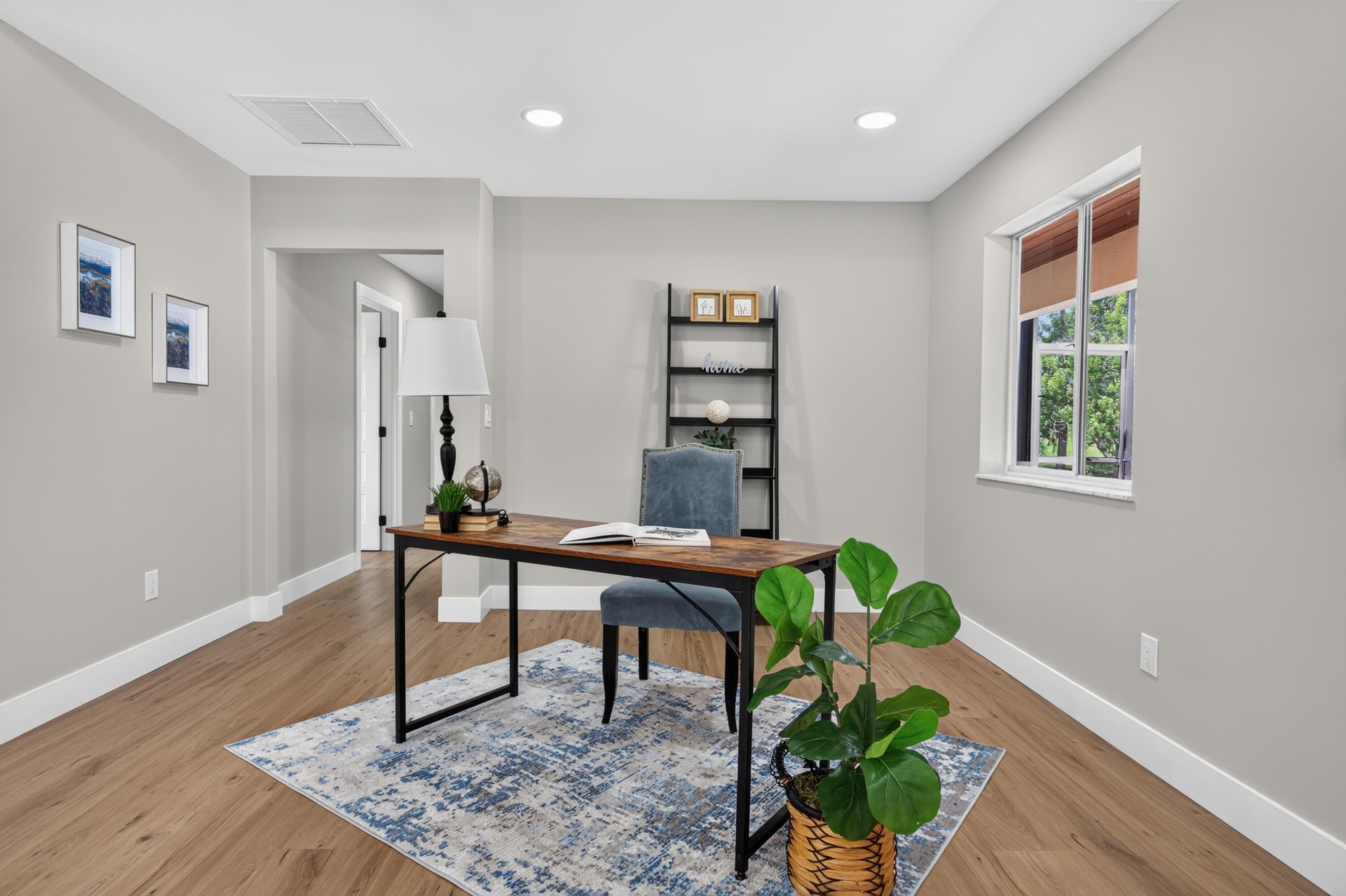 Room featuring wood-finish flooring, recessed lighting, a single window, and a doorway