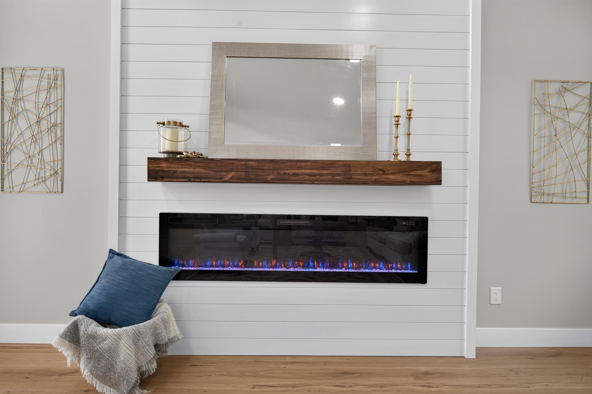 Shiplap accent wall featuring a linear electric fireplace with a wood mantel