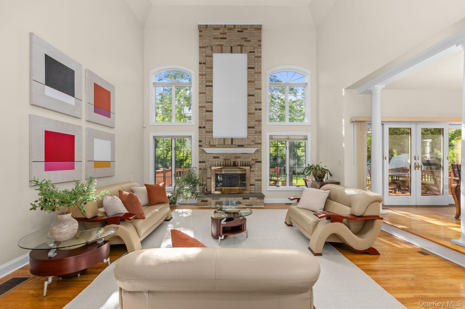 Vaulted ceilings, walls of windows, and a floor-to-ceiling brick fireplace define this spectacular family room.