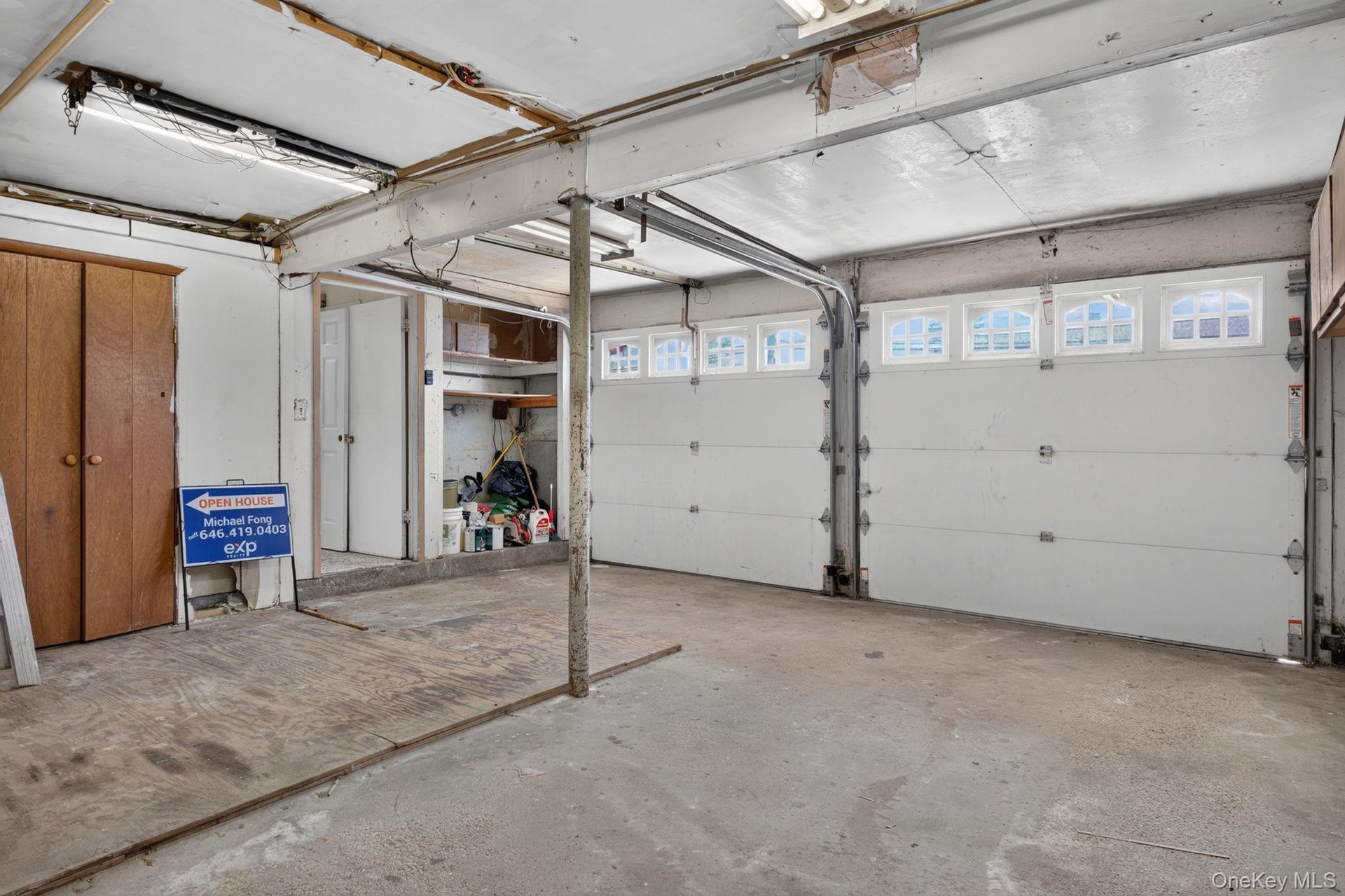 Two white garage doors with arched window panels