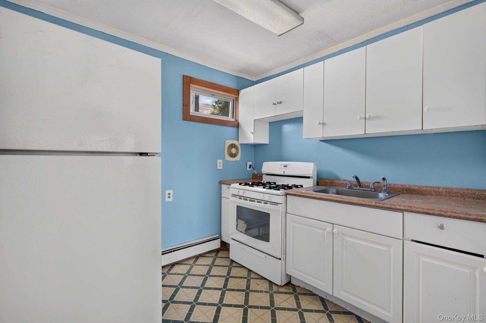 1st Floor Kitchen featuring white cabinetry, a stainless steel sink, and a gas range