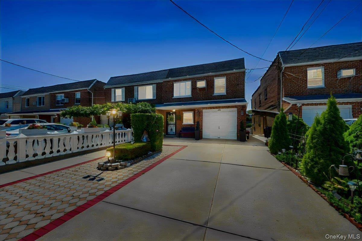 Brick facade residence featuring an integrated garage & driveway